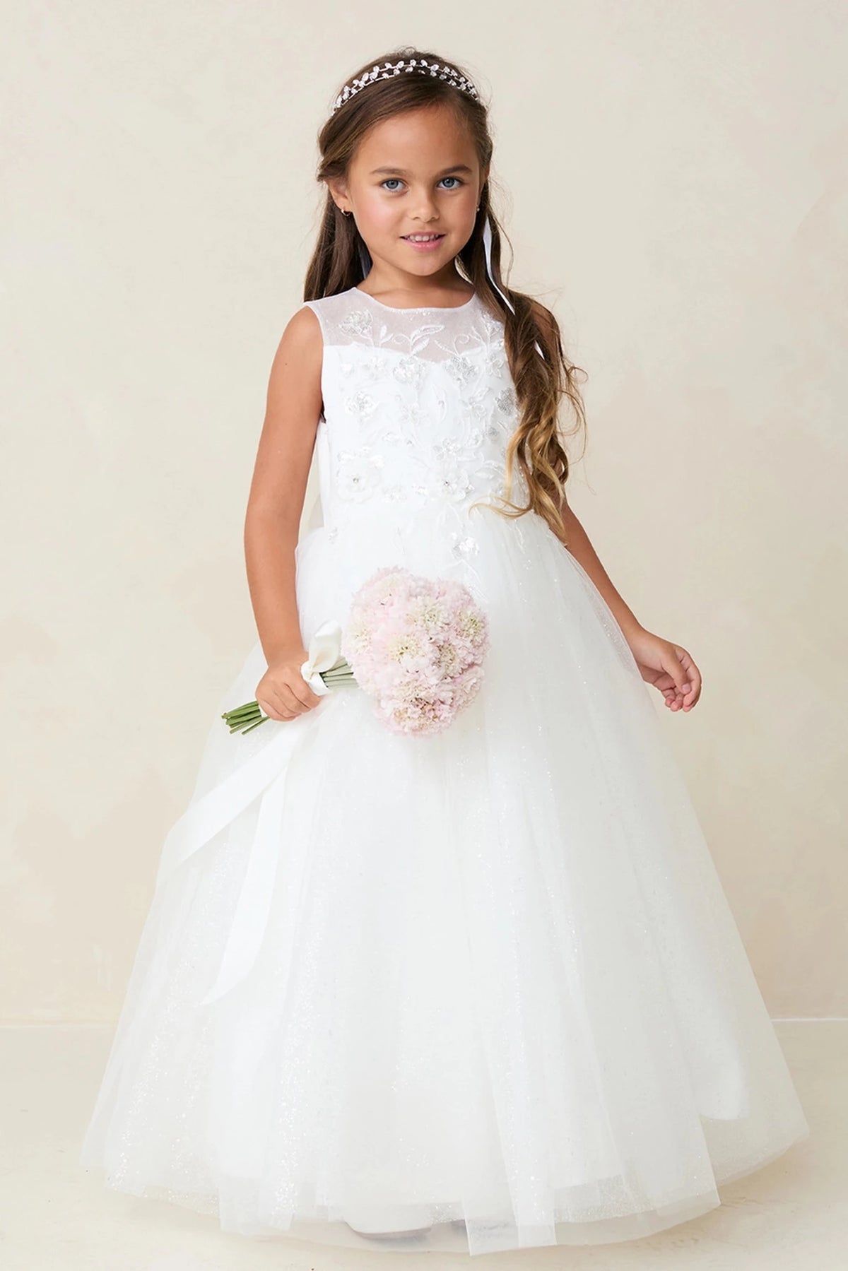 Shown here, an off-white flower girl dress with a floral shoulder applique.