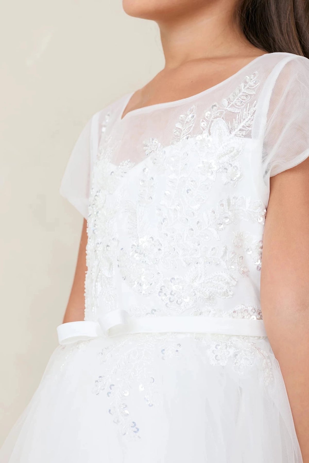 Shown here, an off-white flower girl dress with a beaded floral bodice.