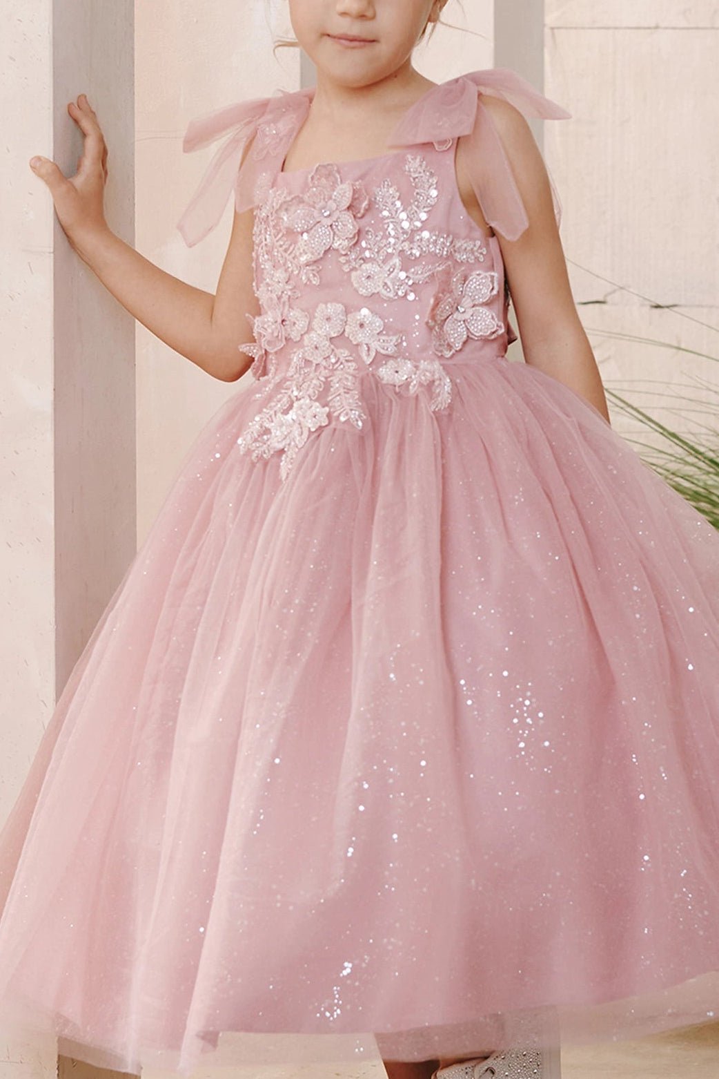 On this dusty rose flower girl dress, 3D bodice flowers are visible.