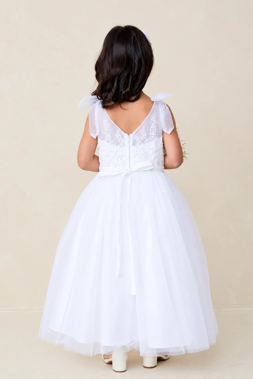 Sheer V back accents the white flower girl dress.