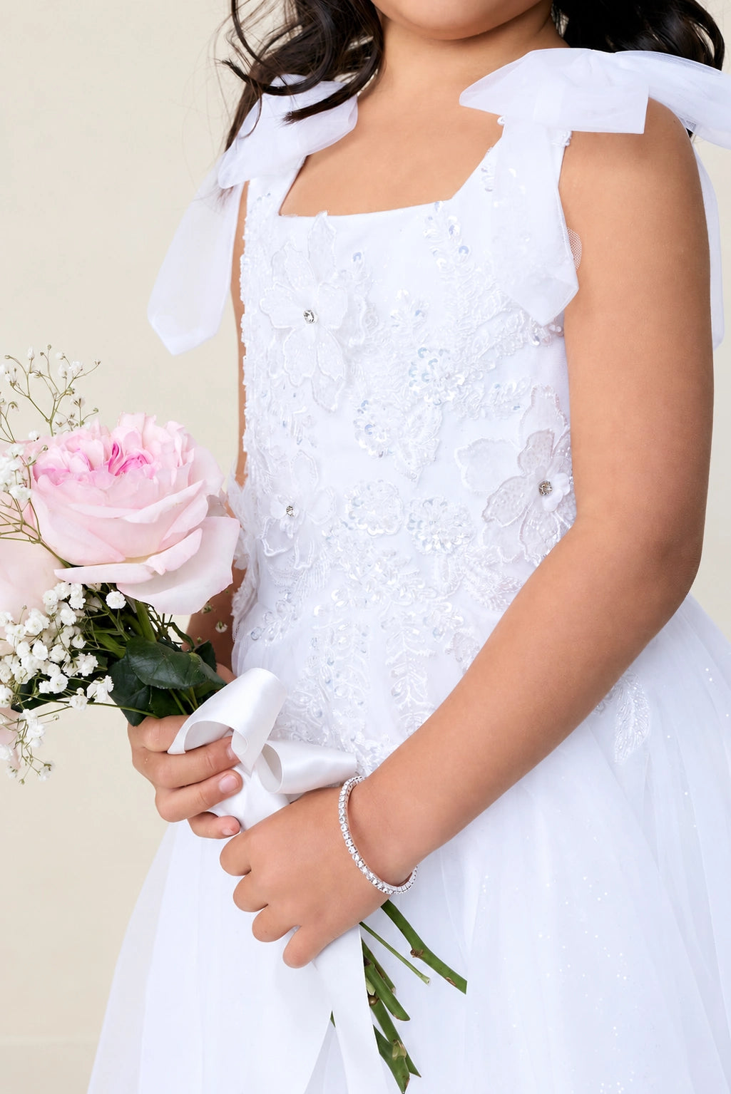 The white flower girl dress features 3D flower appliques.