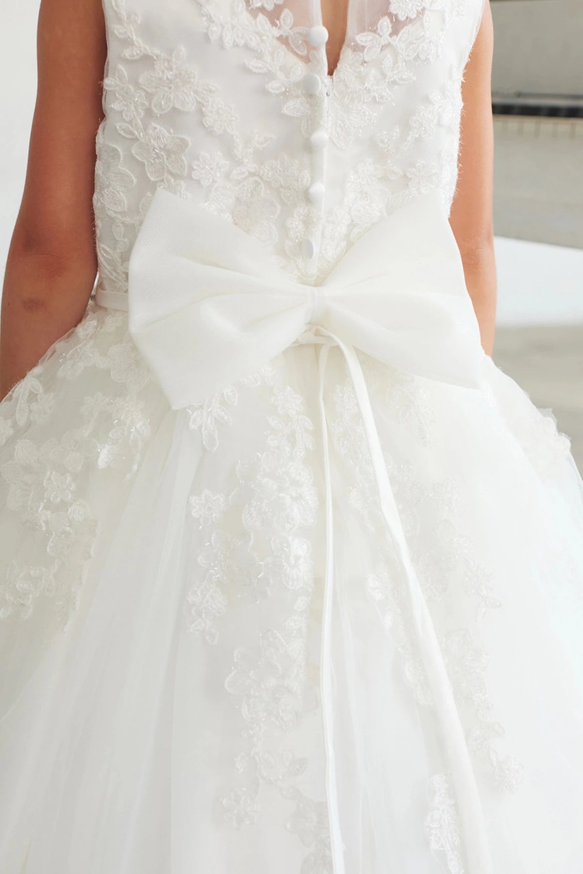 The off-white flower girl dress features a large satin back bow.