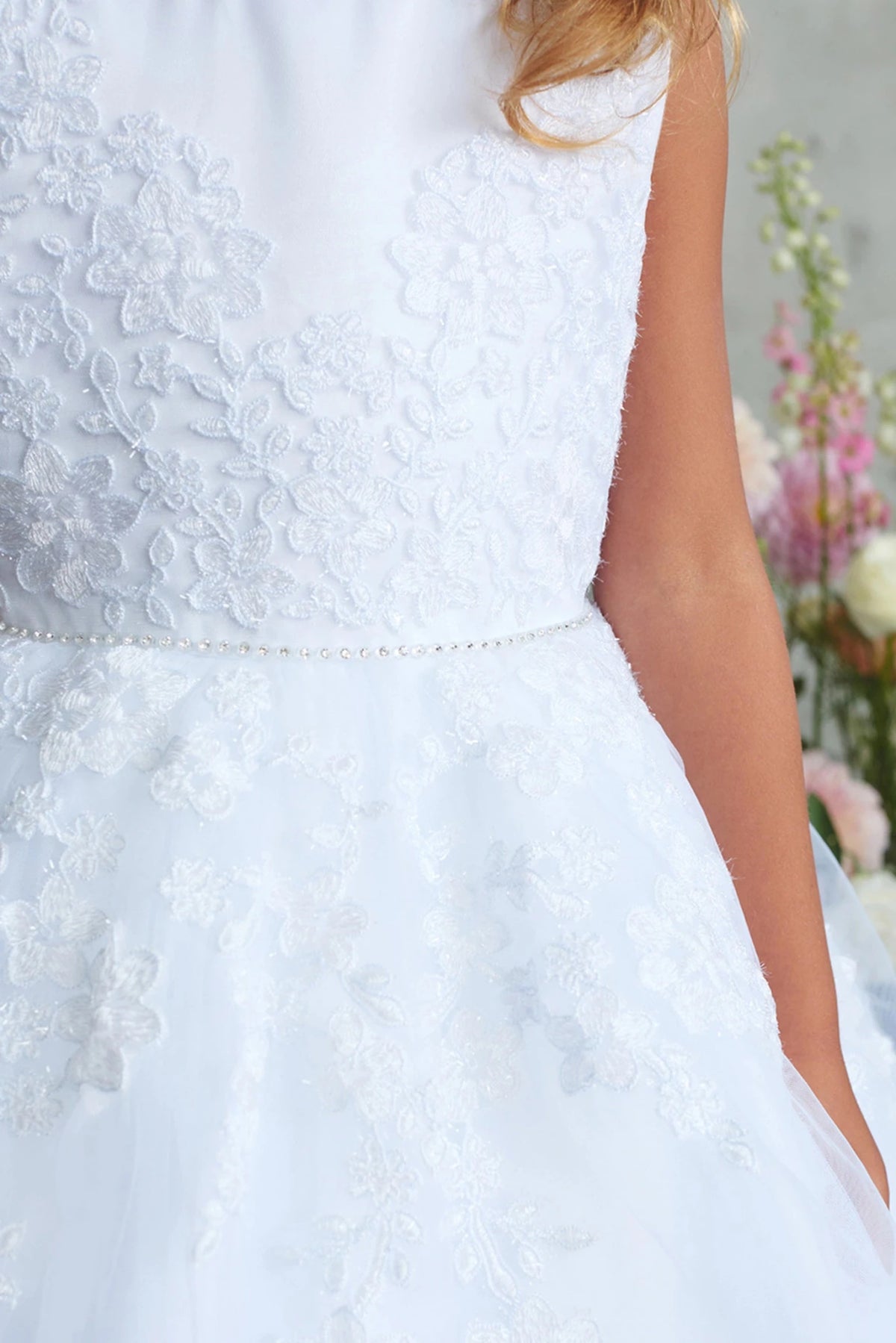 A view of floral bodice embroidery on the white flower girl dress.