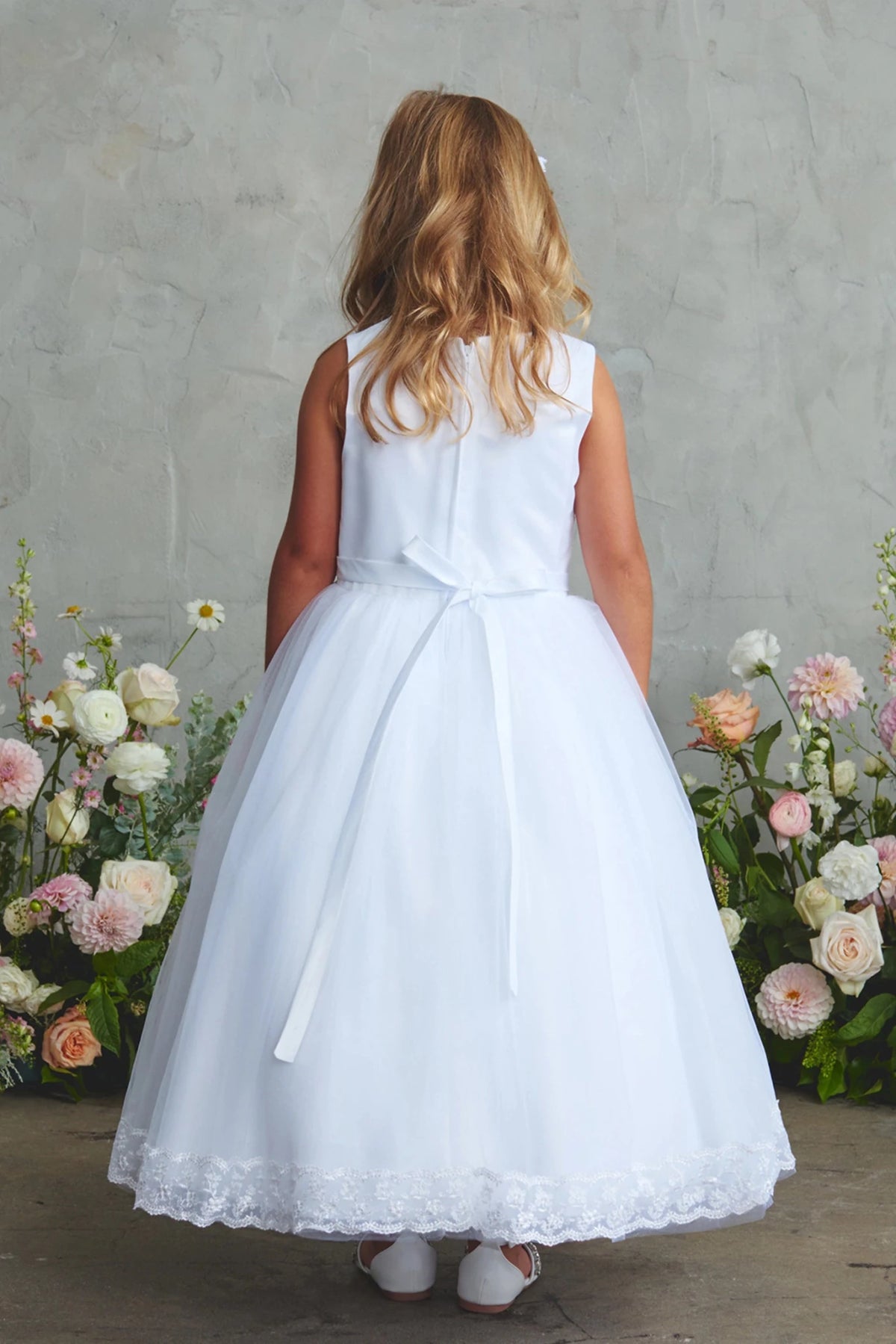 The white flower girl dress features a small back ribbon.