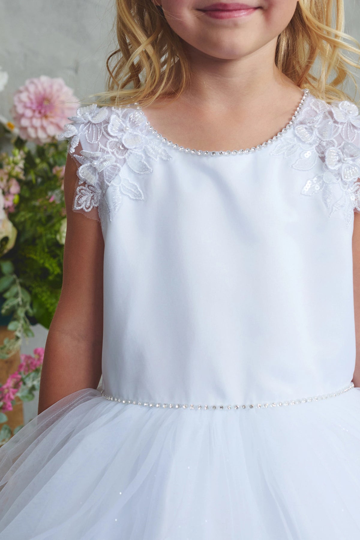 Floral shoulder trim: detail of the white flower girl dress.