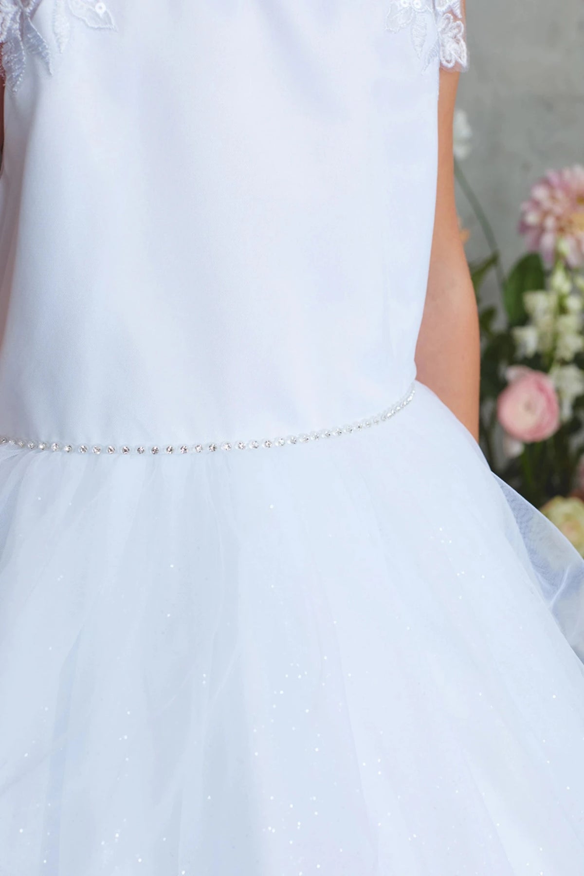 Emphasis on a thin beaded waistband of the white flower girl dress.