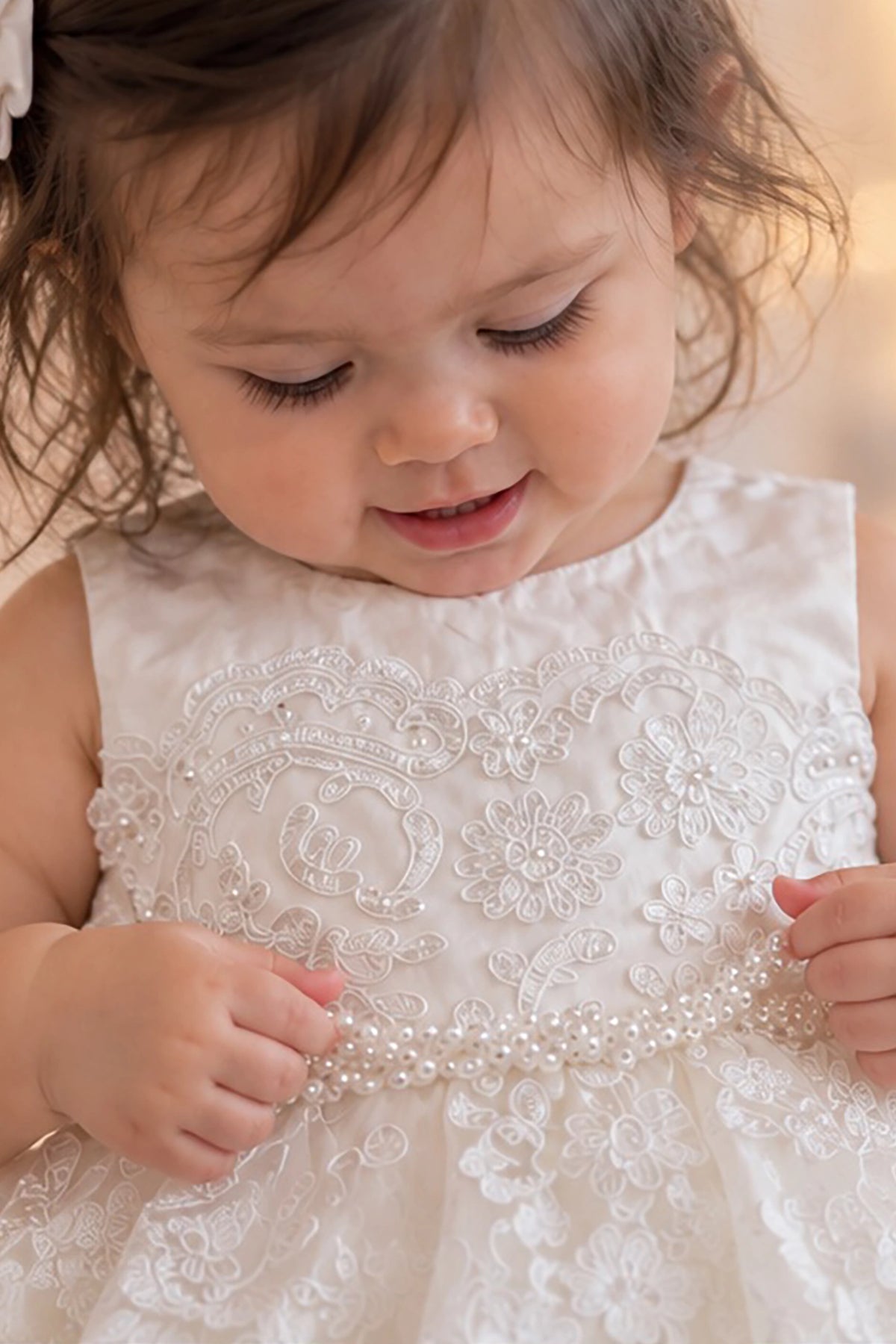 Braided pearls accent the waist of the ivory flower girl dress.