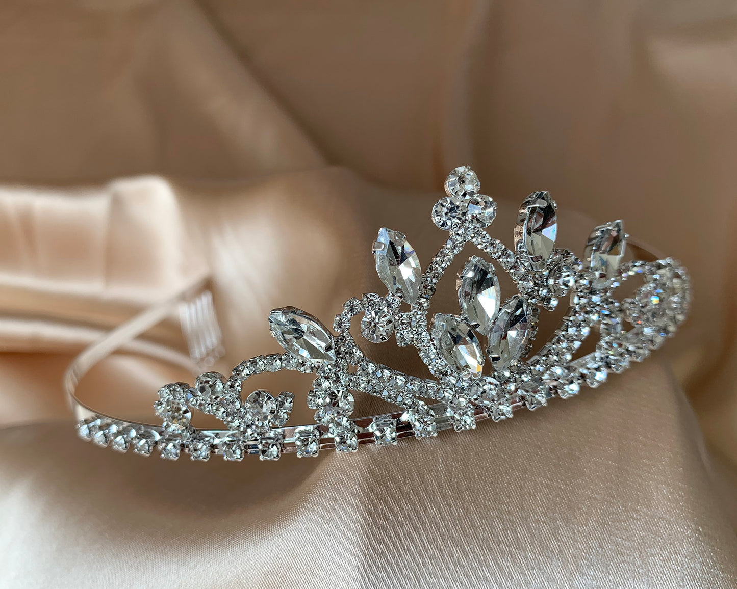 Silver rhinestone flower girl tiara, close-up, side view, embellishment detail.
