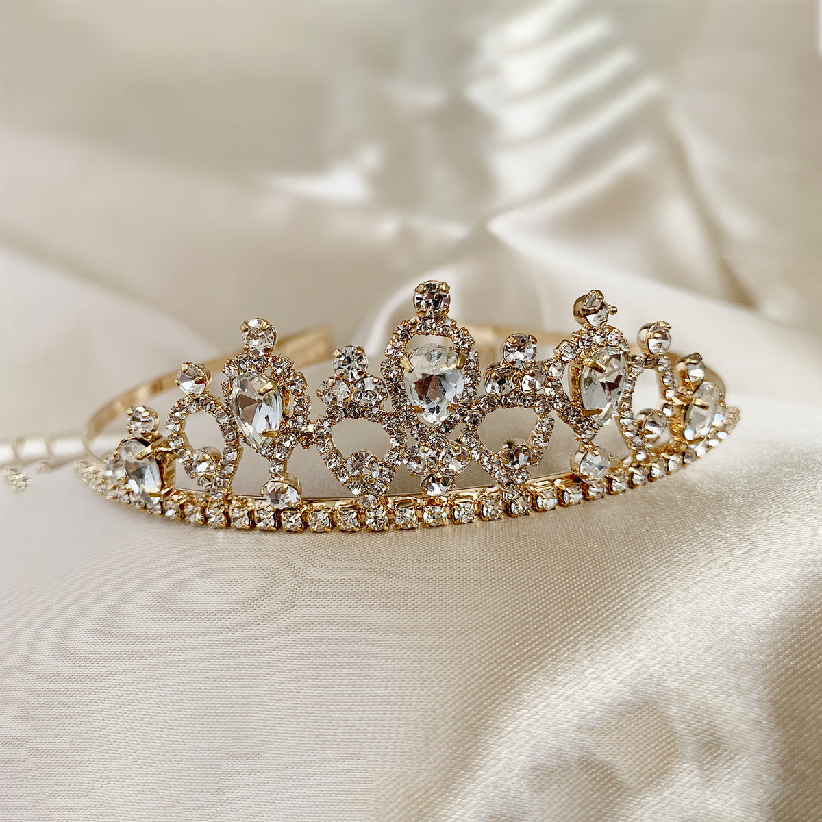 Close-up view reveals gold rhinestone flower girl tiara, close-up, embellishment detail.