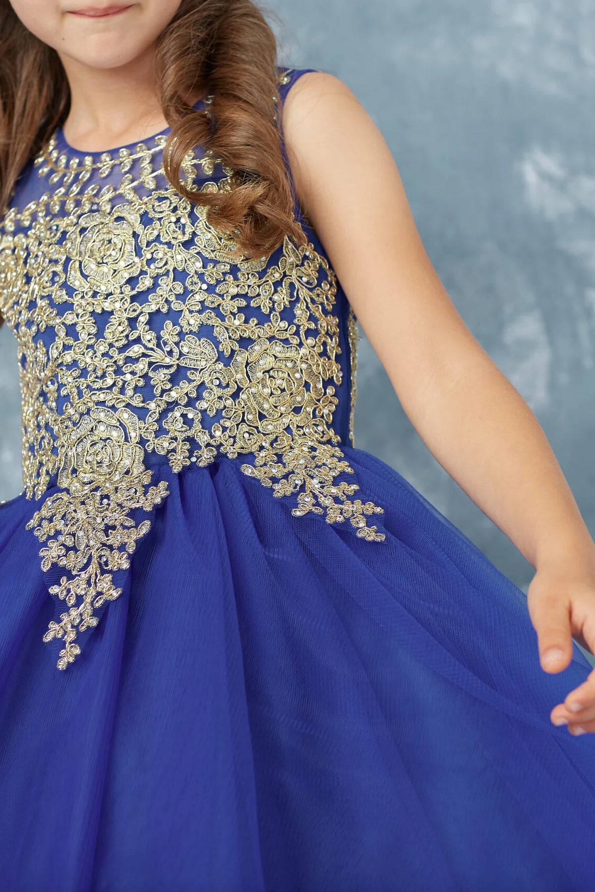 The Royal Blue kids pageant dress has metallic lace across the upper bodice.