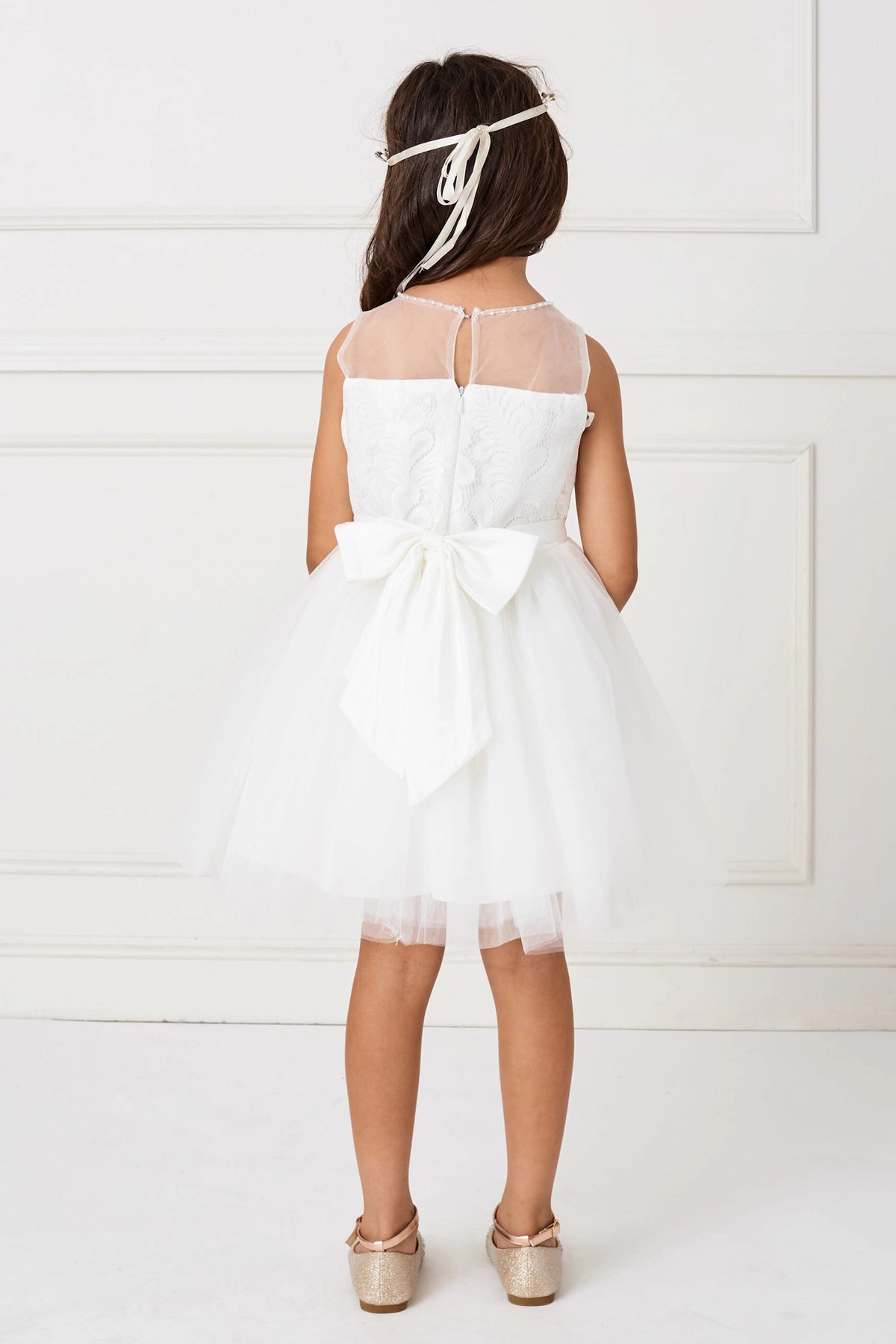 Detailed with a large satin back bow, this white flower girl dress.