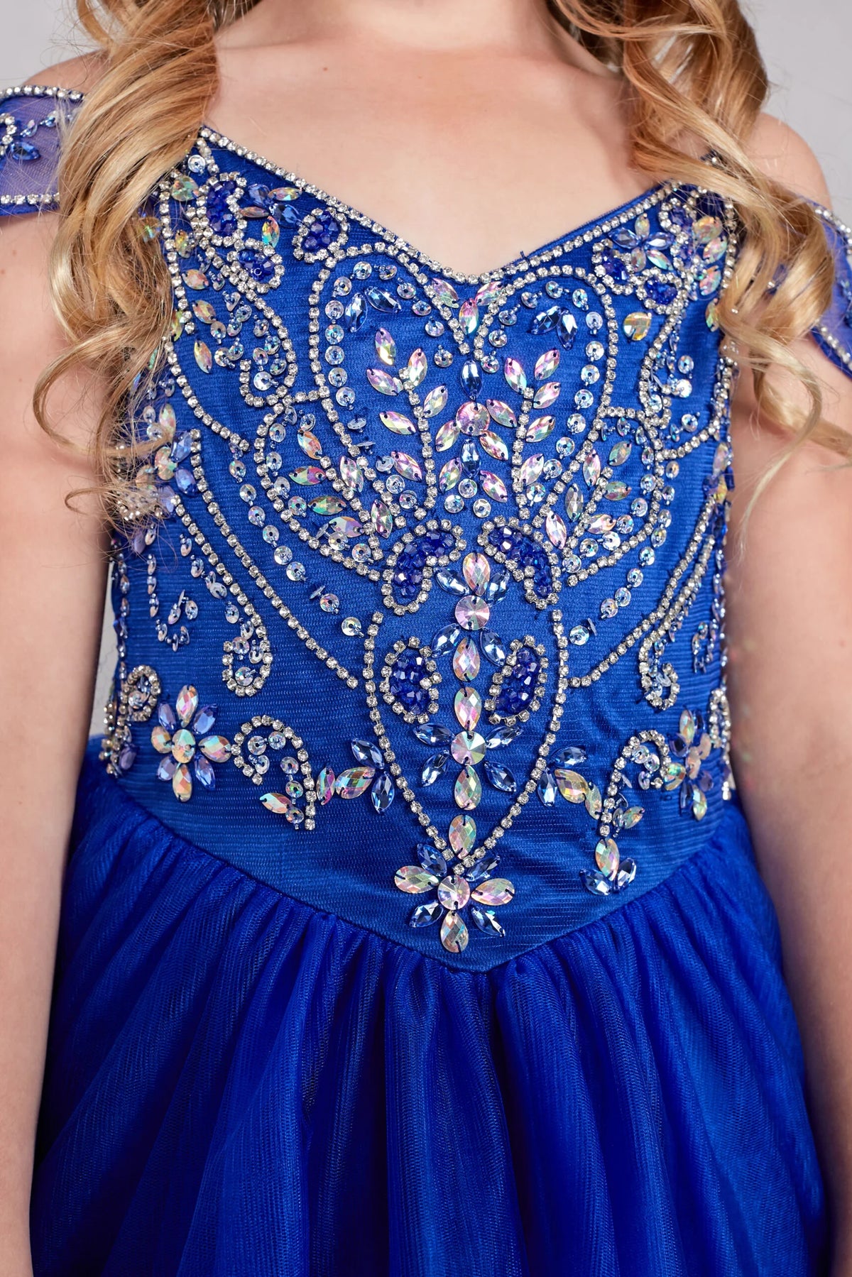 The Royal Blue kids pageant dress has rhinestones on the royal blue bodice.