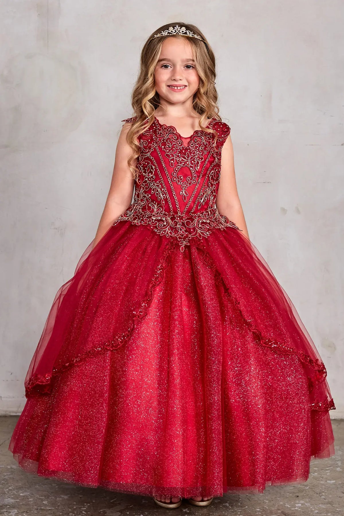 Burgundy pageant dress displays metallic embroidery and lace-edged split skirt panels.