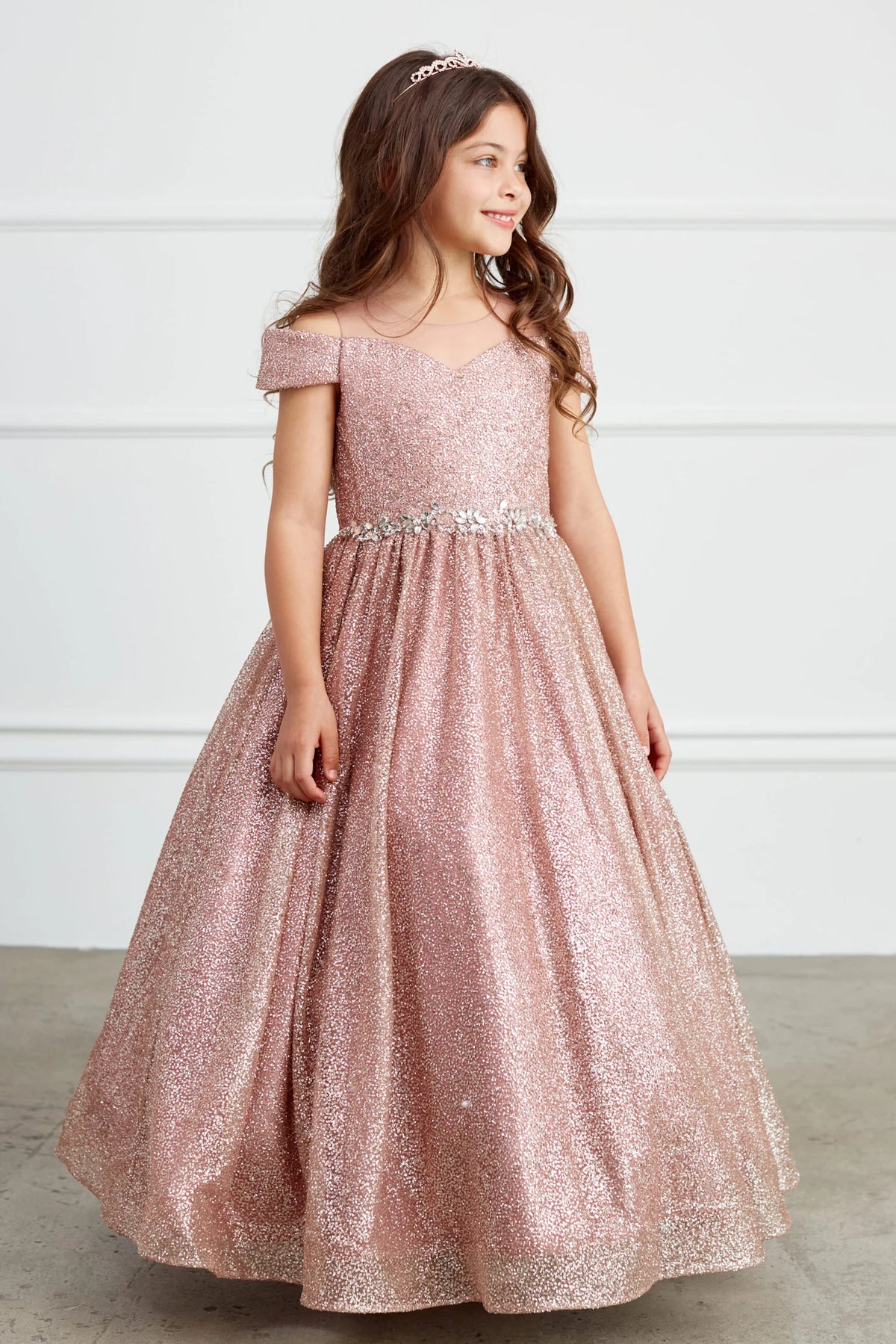 The Rose Gold kids pageant dress has a rhinestone waist and glitter skirt.