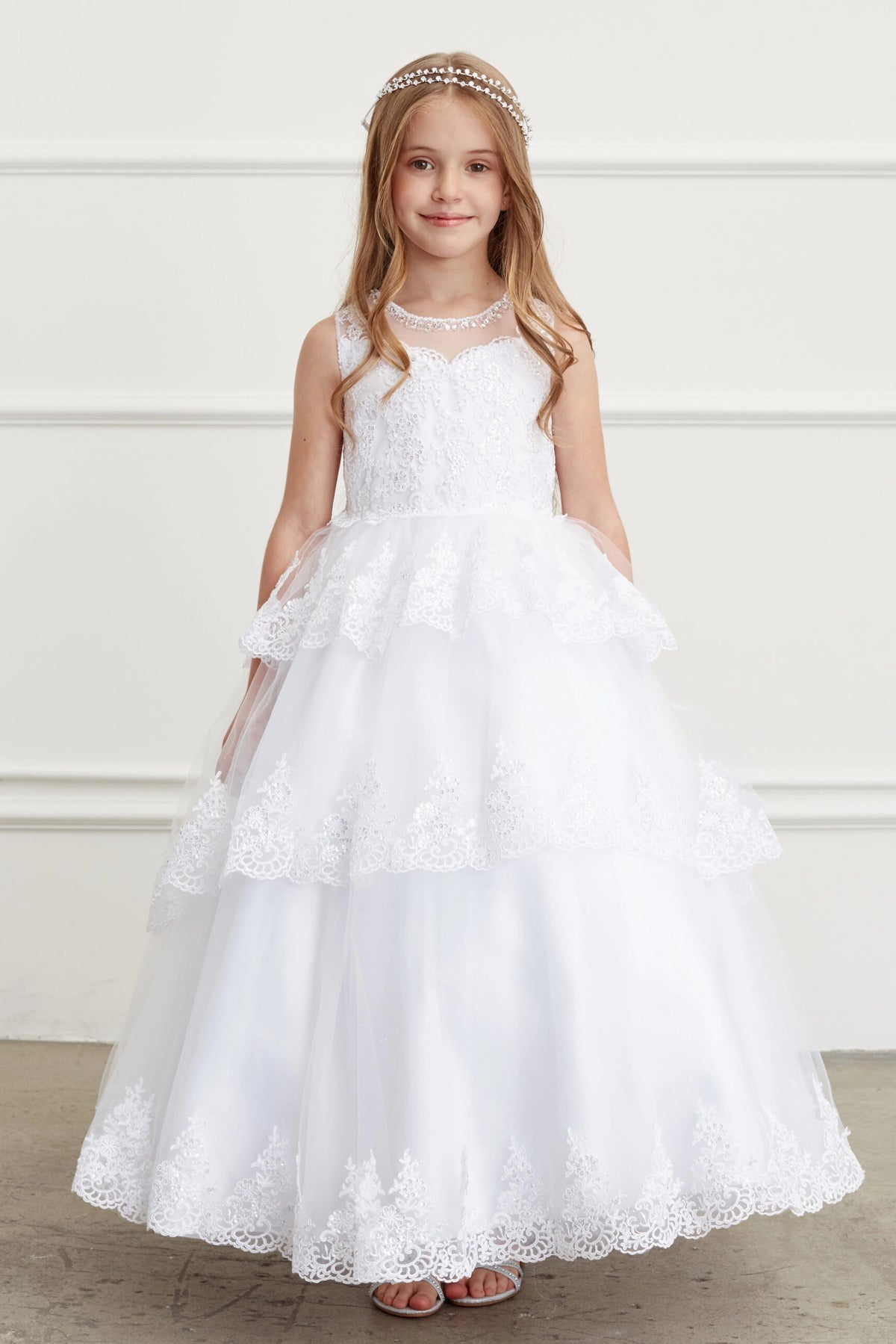 The White kids pageant dress has corded lace edging on layered tulle.