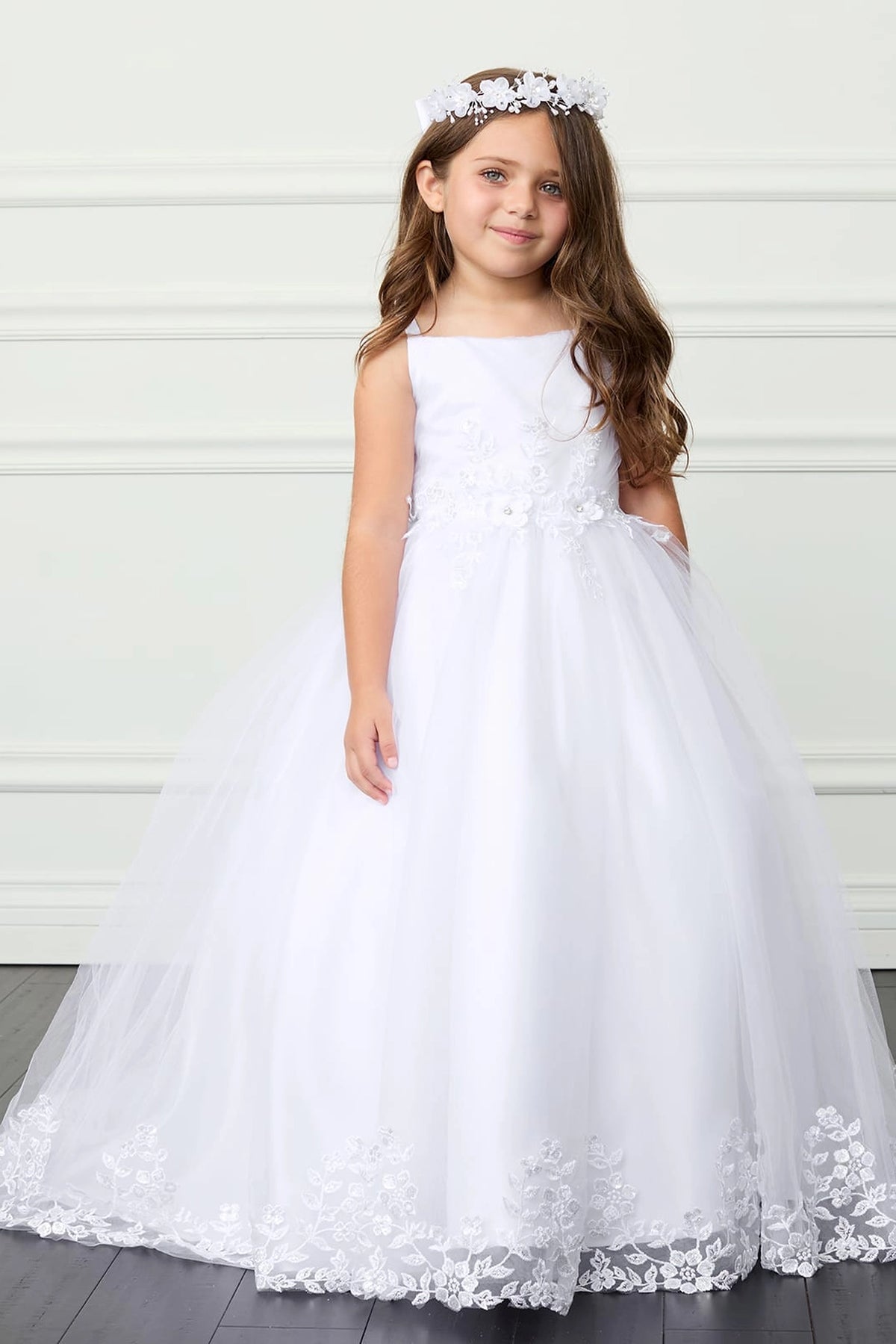White kids pageant dress featuring lace trimming along a flowing train.