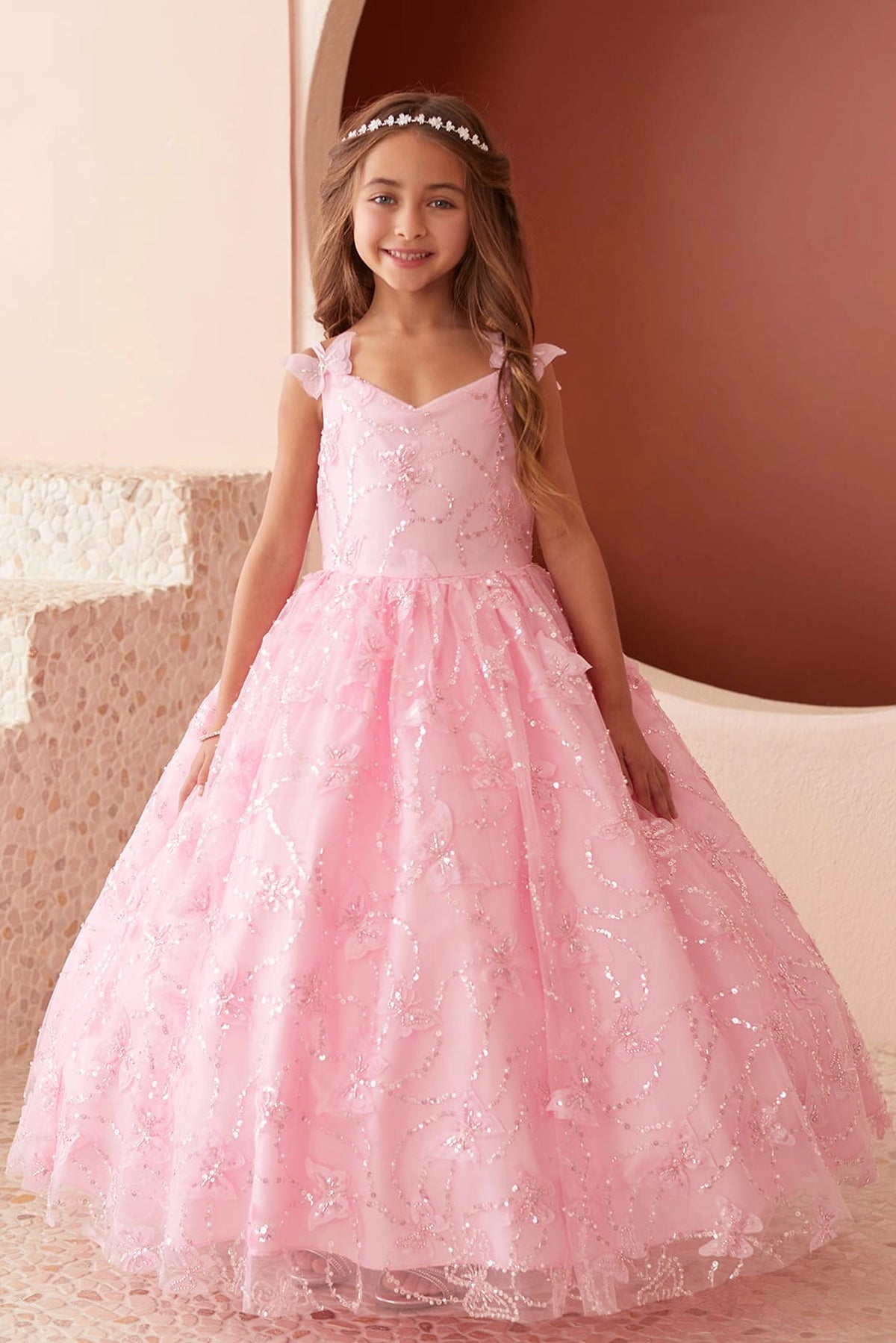 Seen from the front, this Pink kids pageant dress displays raised butterfly details.