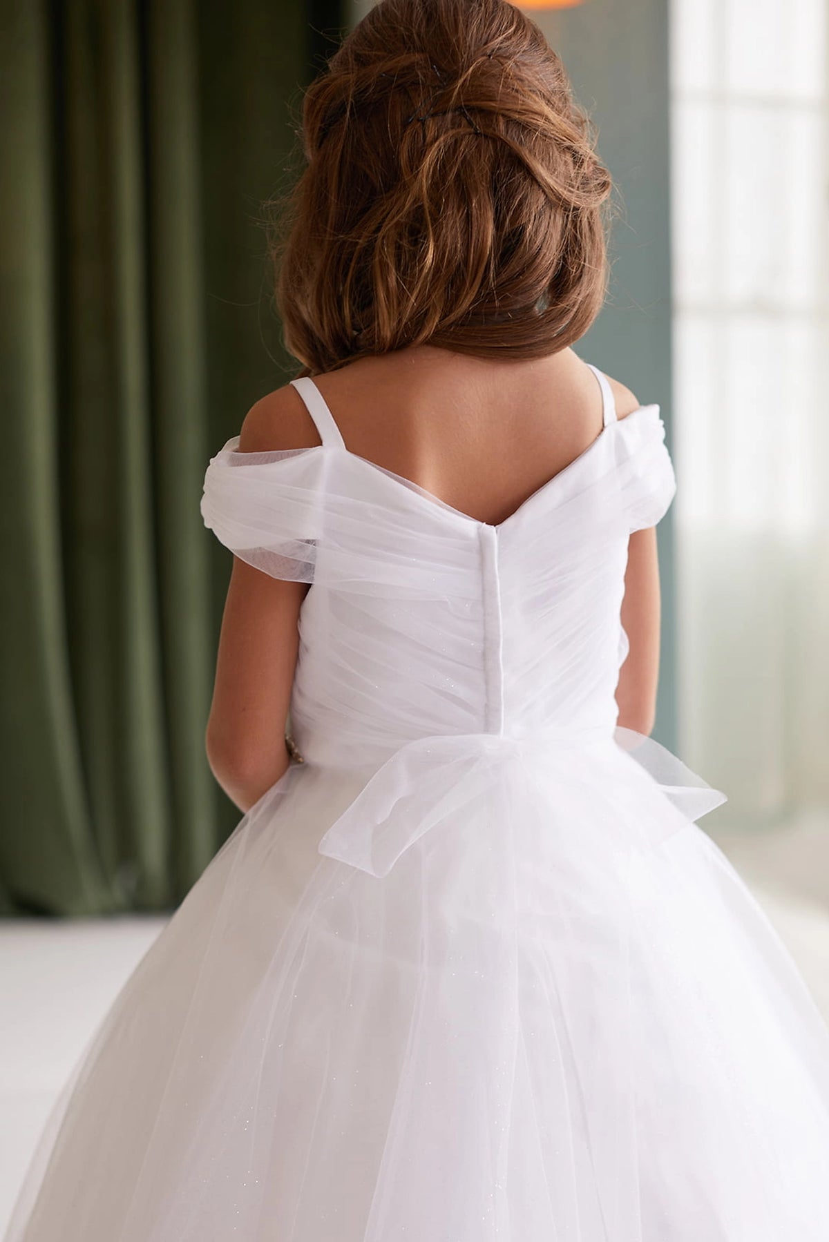 Seen from behind, this White kids pageant dress displays a tied sash across the back waist.