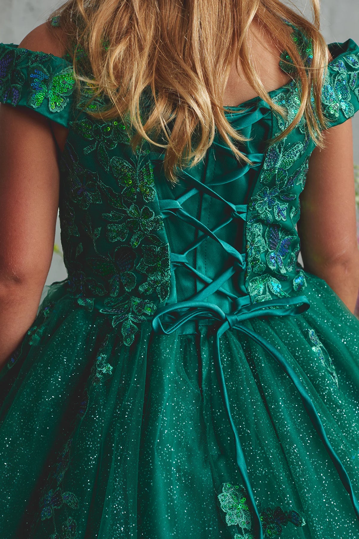 Seen from up close, this Emerald kids pageant dress displays lace-up ties at the back waist.