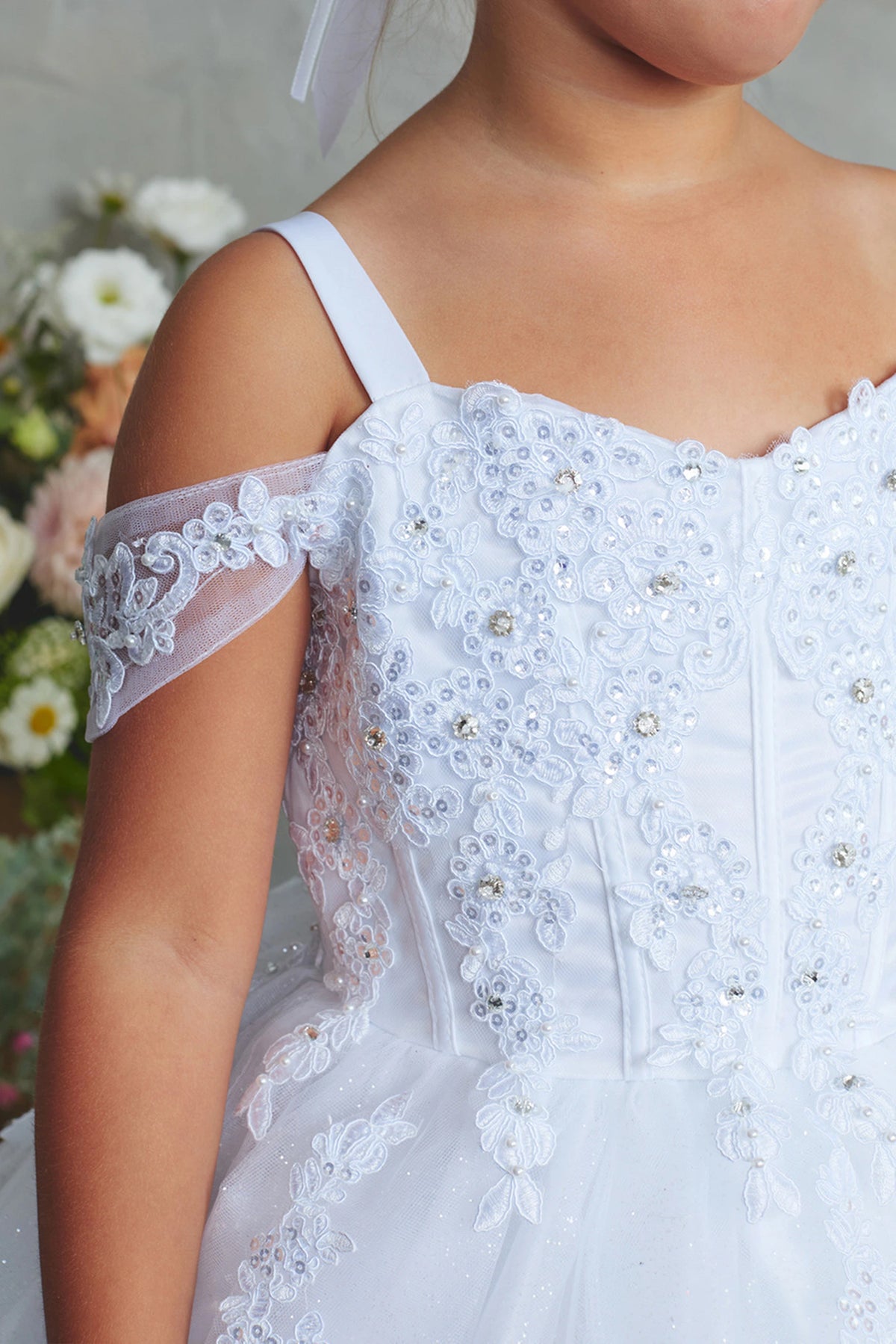 Seen from up close, this White kids pageant dress displays beaded lace along the sweetheart neckline.
