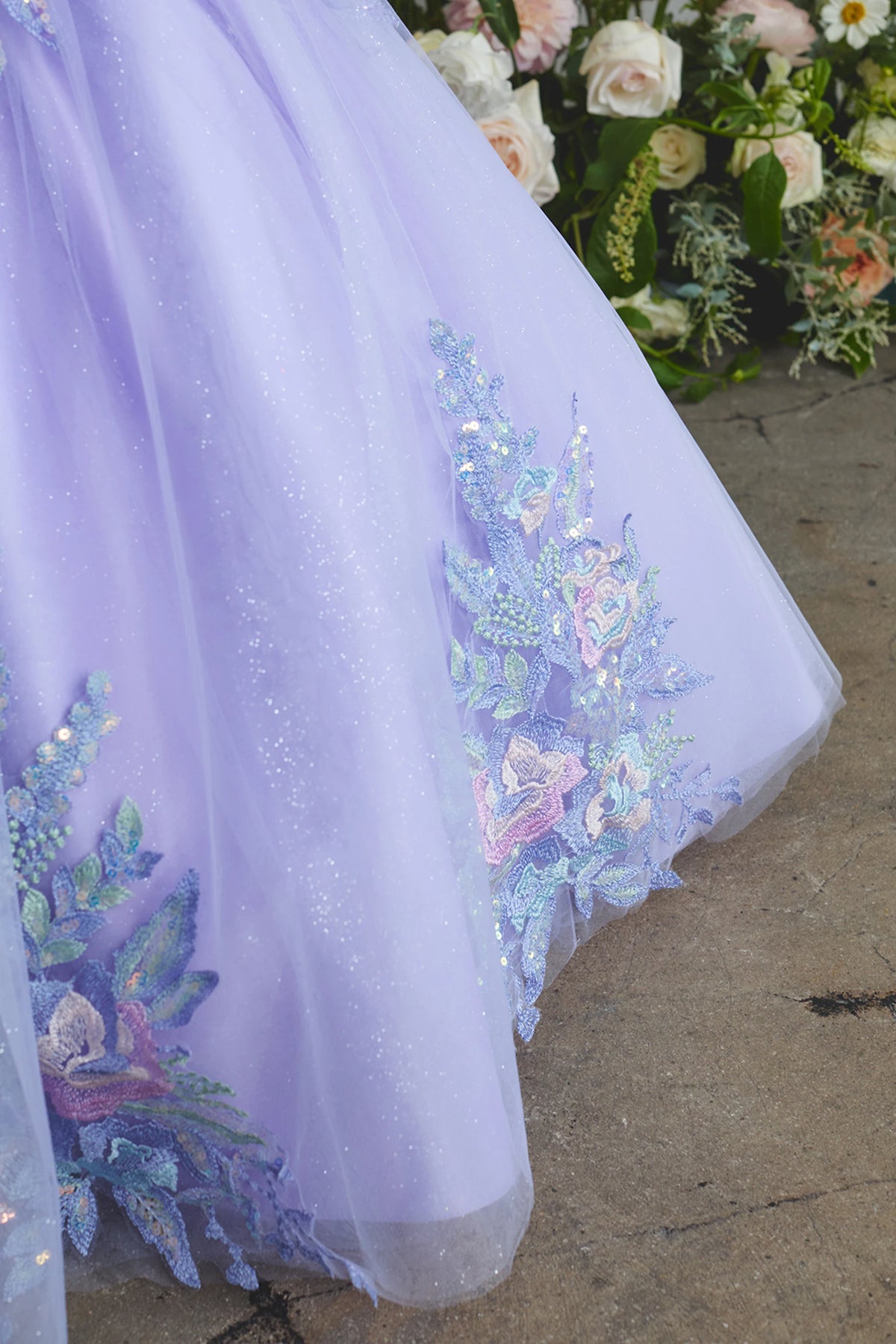The Lilac kids pageant dress has floral lace on the full skirt.