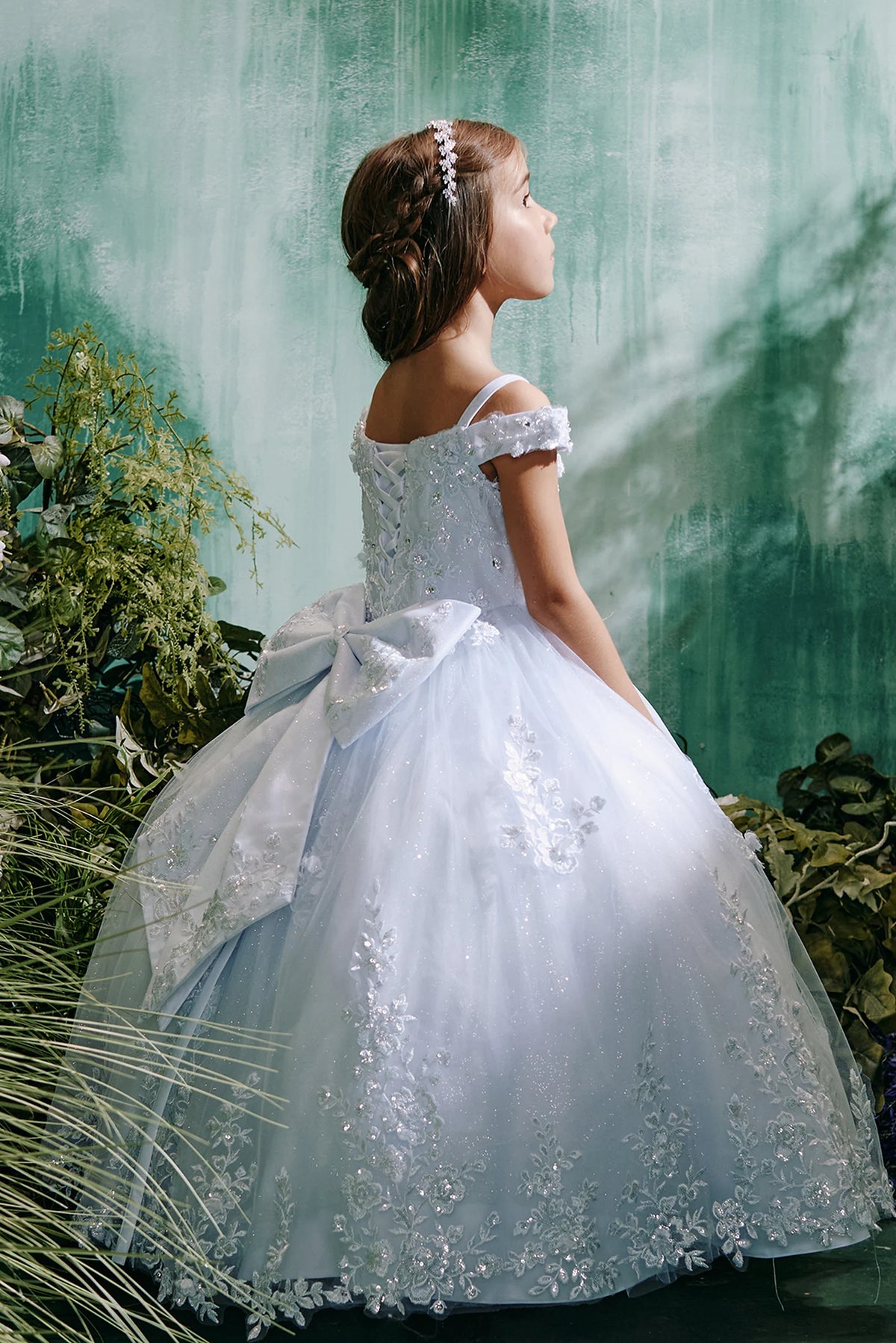 The White kids pageant dress has lace appliques on a glitter tulle skirt.