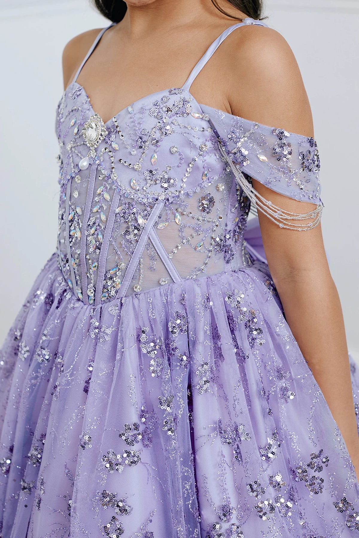 Seen from up close, this Lilac kids pageant dress displays beaded seams across the waist.