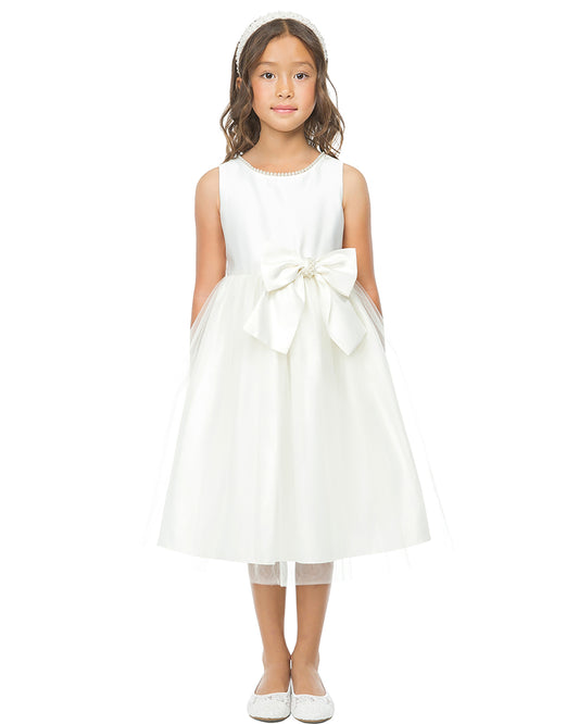 Young girl wearing a Ivory dress with a large bow on a white background