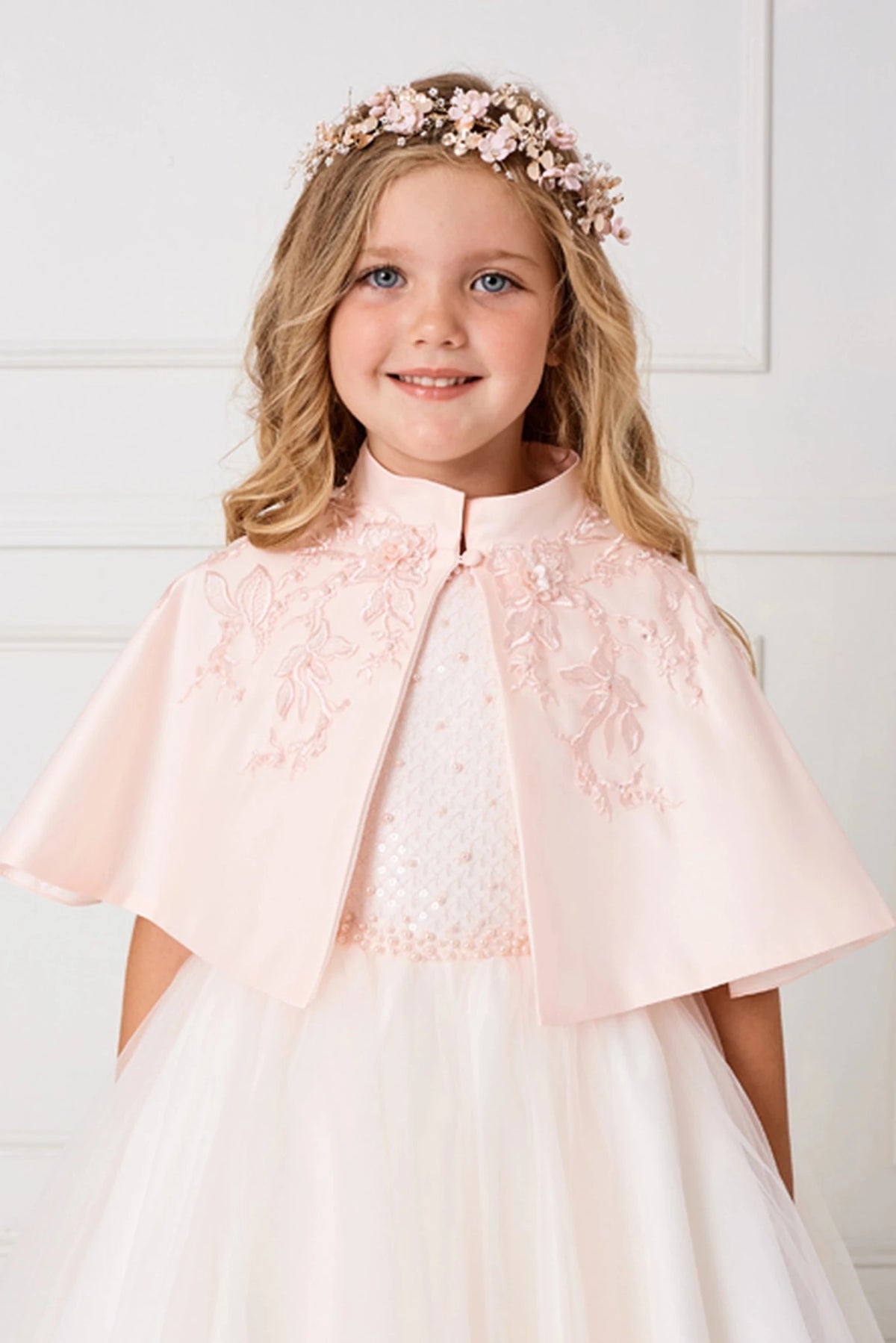 Blush satin cape with floral appliqué and a softly draped shape.