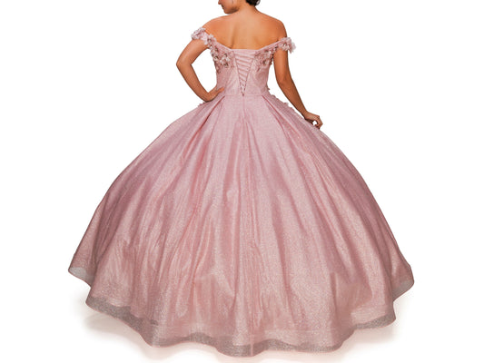 Dusty Rose Quinceanera | 6 Colors | 3D floral off-shoulder ball gown with glitter skirt, bottom pleated, corset back tie - back view of woman wearing dress with one hand on hip
