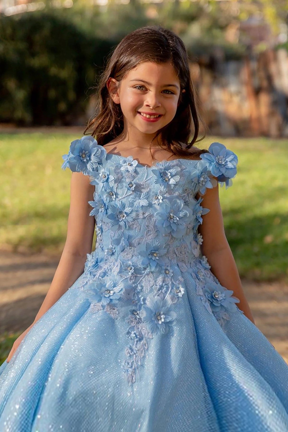 Intricate features stand out across Light Blue quinceanera ball gown with floral appliques, glitter accents, and pleated beaded skirt.