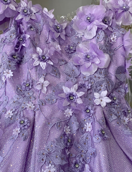 Close-up of a purple embroidered fabric with floral patterns and beads.
