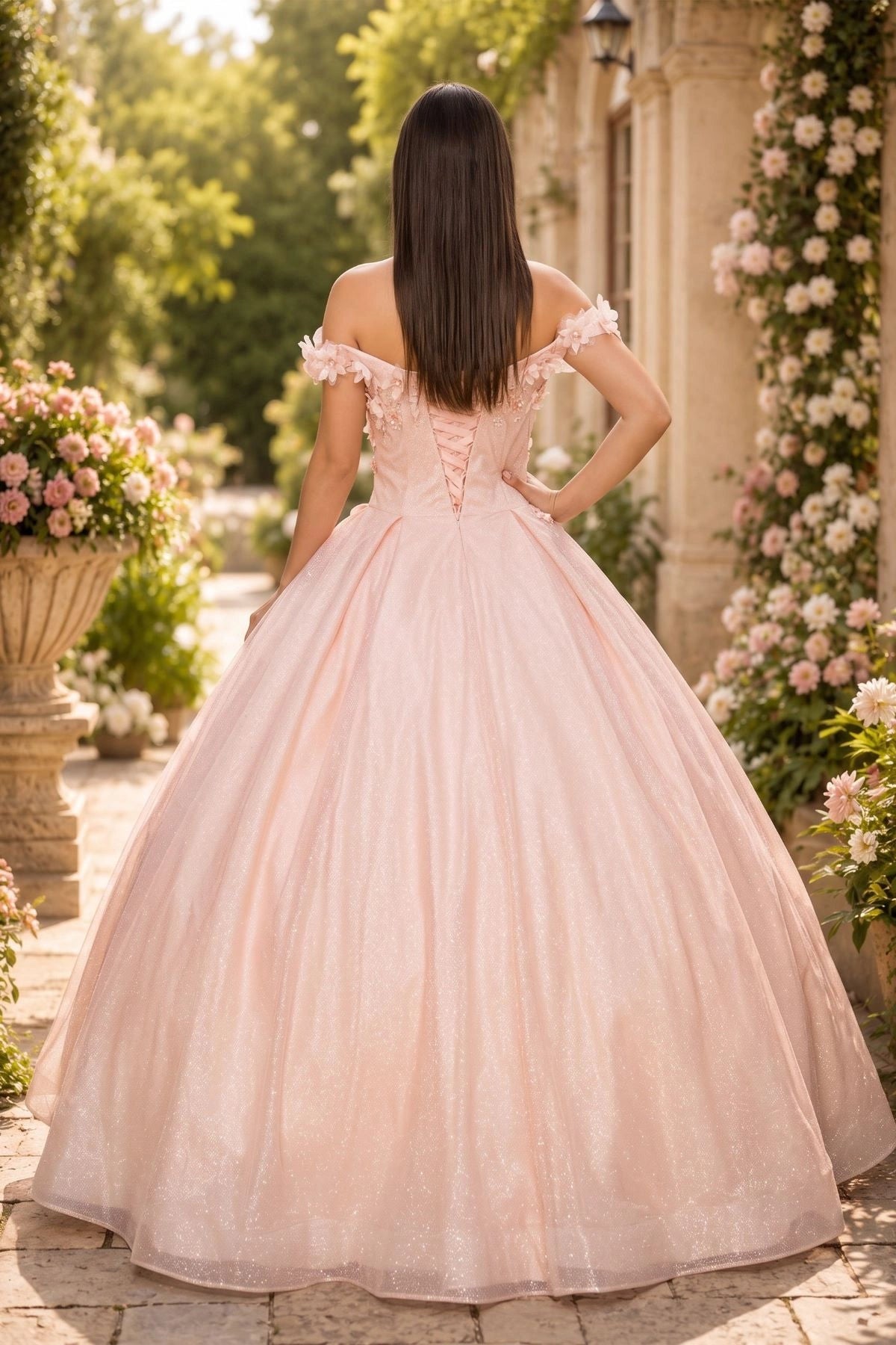 Displayed in a back view, the Blush quinceañera dress has lace-up back and full pleated glitter skirt.