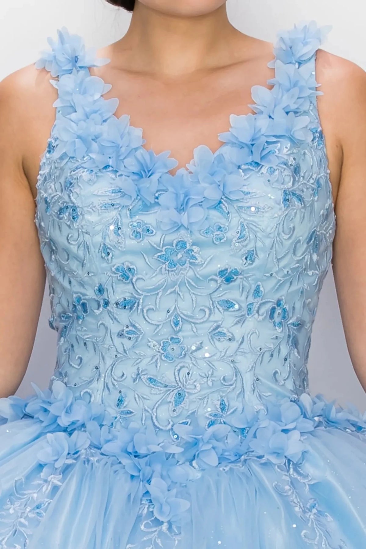 Zoomed front view of a blue quinceanera dress highlighting 3D floral appliques, beadwork bodice, and glitter embellishments