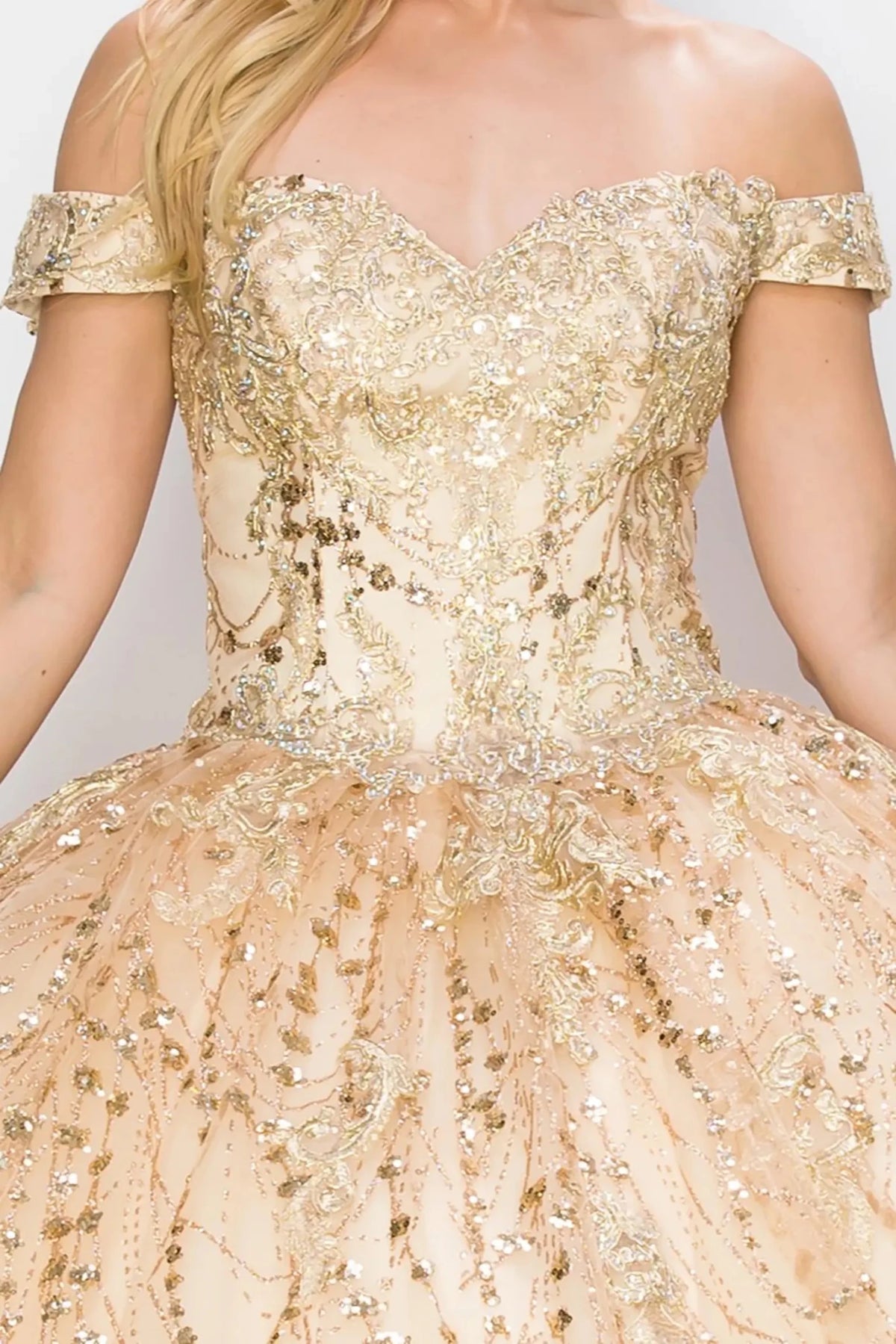 Close-up view reveals a champagne quinceanera ball gown with sweetheart neckline, gold embroidery, and glitter bodice.
