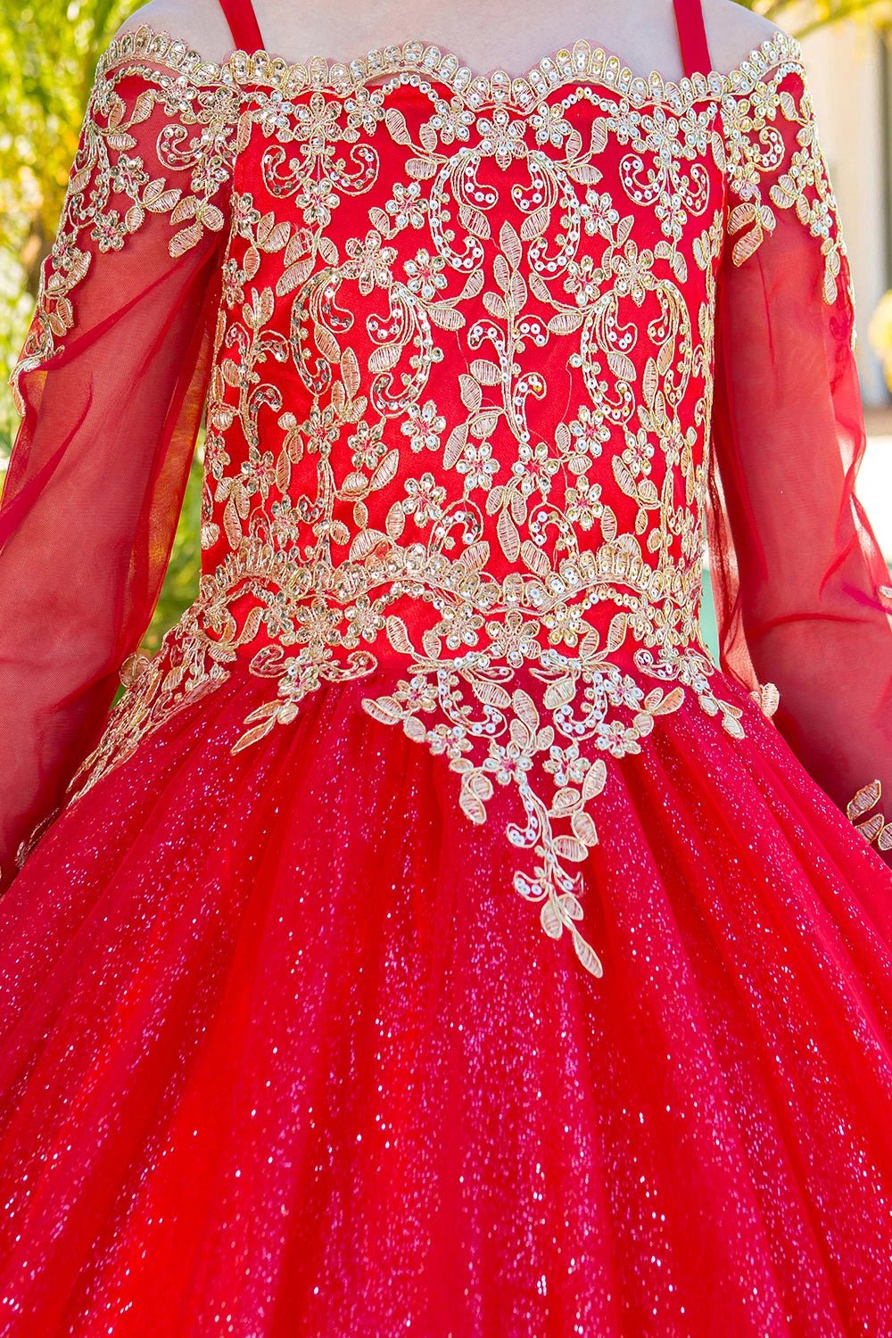 Shown in a bodice detail, the Red mini quince dress has gold lace embroidery across the neckline and sheer sleeves.