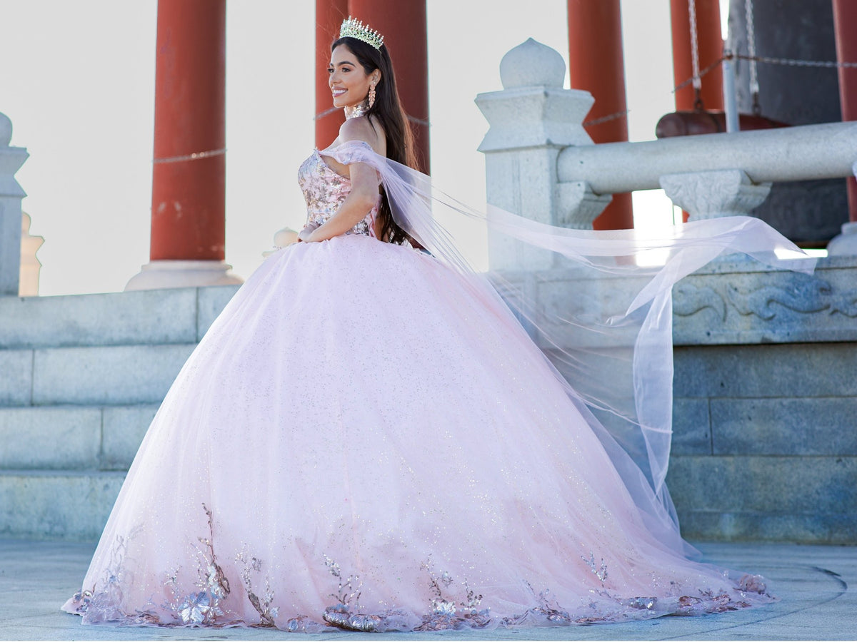 Side profile shows blush quinceanera ball gown with golden lace, detachable shoulder train sleeves, and glitter tulle skirt.