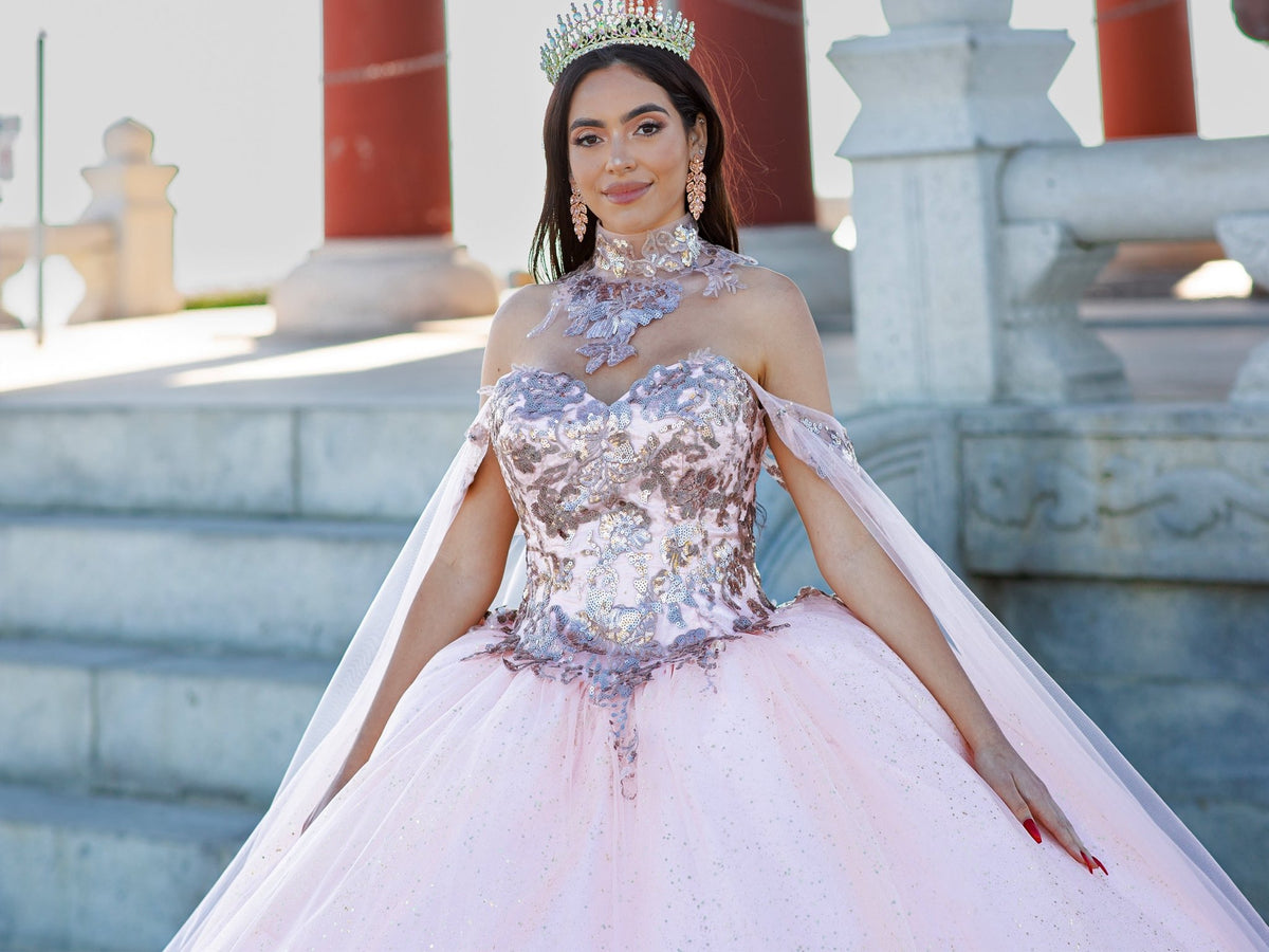Bodice close-up highlights blush quinceanera ball gown with golden lace, detachable shoulder train sleeves, and tiara detail.