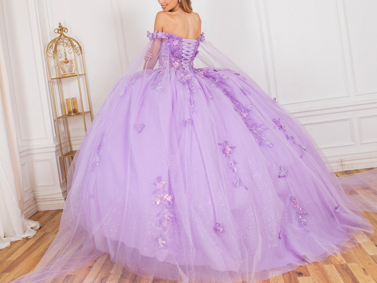 Rear view reveals lilac ball gown with floral appliques, glitter tulle skirt, and off-shoulder neckline.