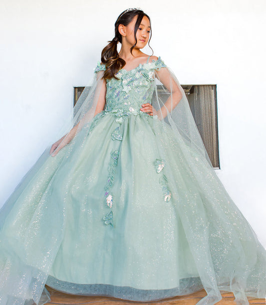 Girl wearing a light blue floral dress with a sheer overlay against a white background