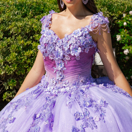Zoomed front view of a woman wearing lilac quinceanera ball gown with lace appliques, sheer corset bodice, and ombre tulle detailing