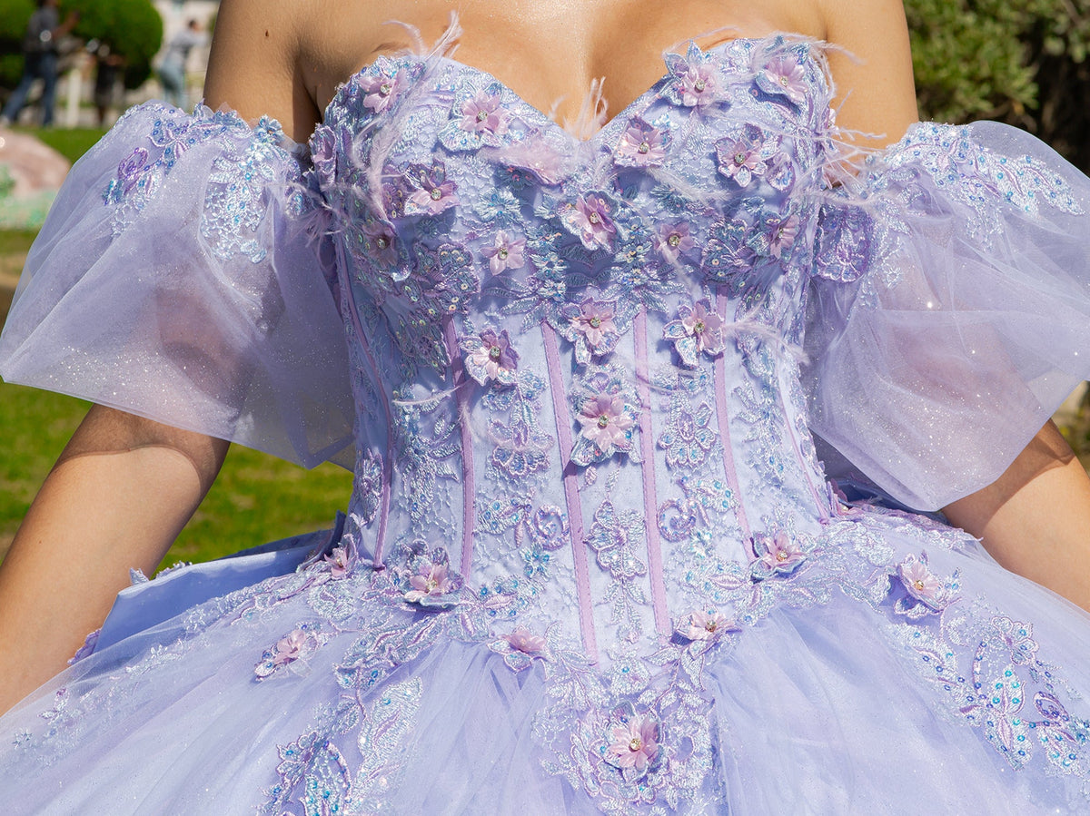 Bodice close-up highlights lilac two-tone quinceanera ball gown with floral embroidery, puff sleeves, and tulle detailing.