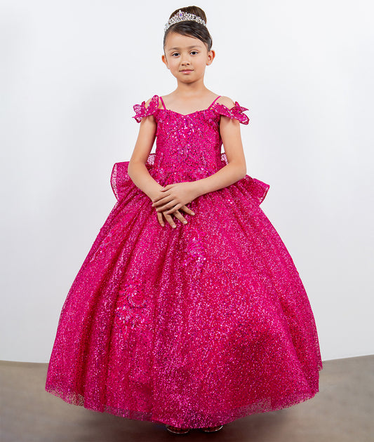 Young girl wearing a pink sparkly dress against a white background