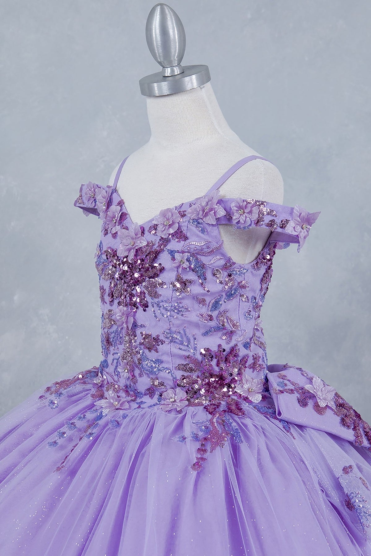 Textured details appear across lilac kids mini quinceañera mini quince dress with off-shoulder 3D beaded floral applique, sequins.