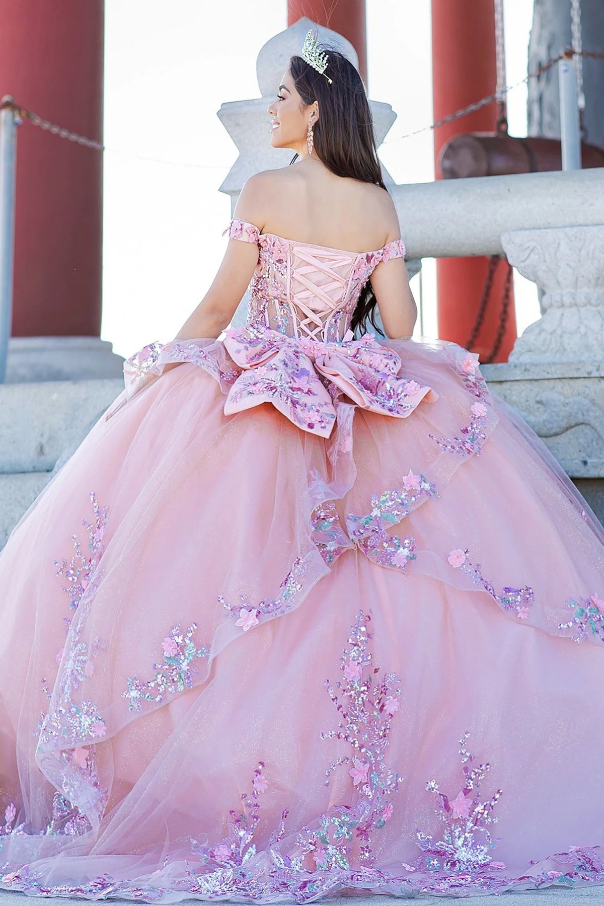 Hemline view highlights peach blush quinceanera ball gown with floral appliques, layered tulle skirt, and glitter detailing.
