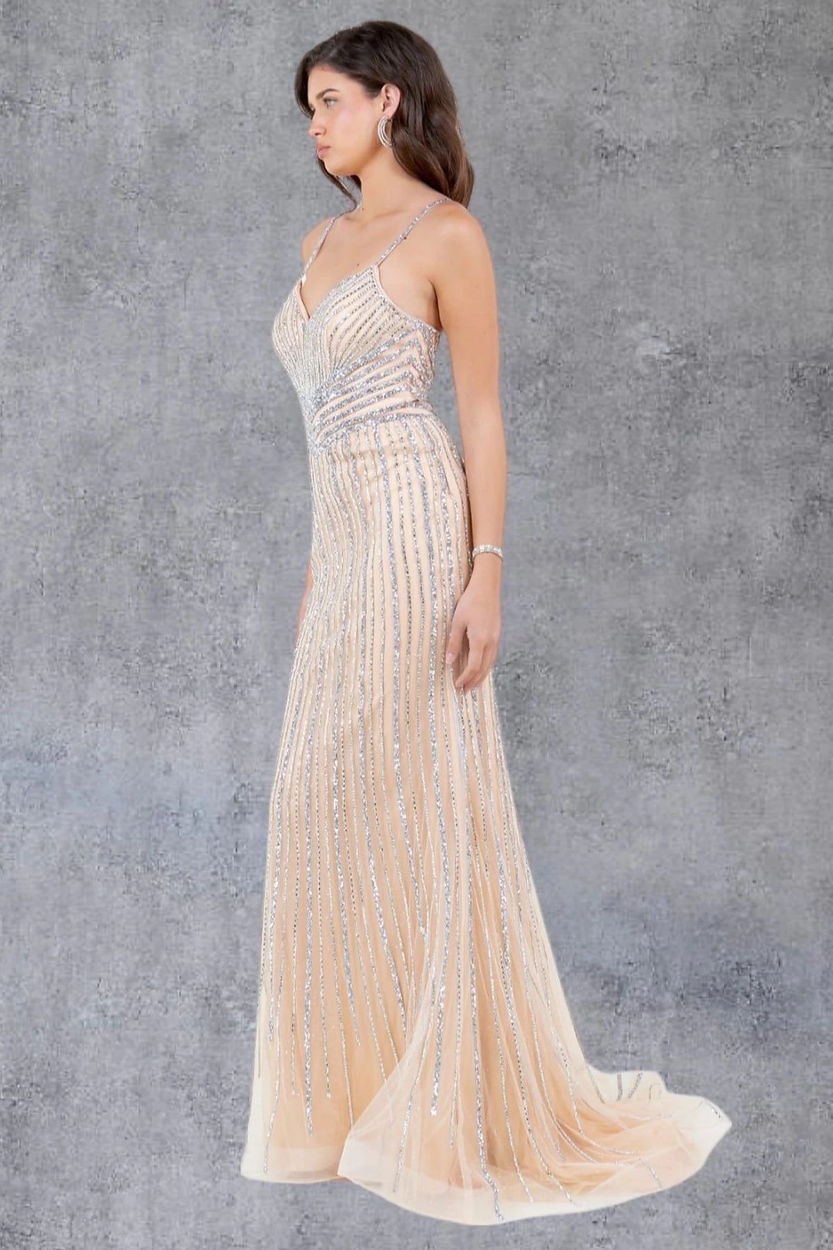 Intricate features stand out across nude evening dress showcasing fitted mermaid silhouette.
