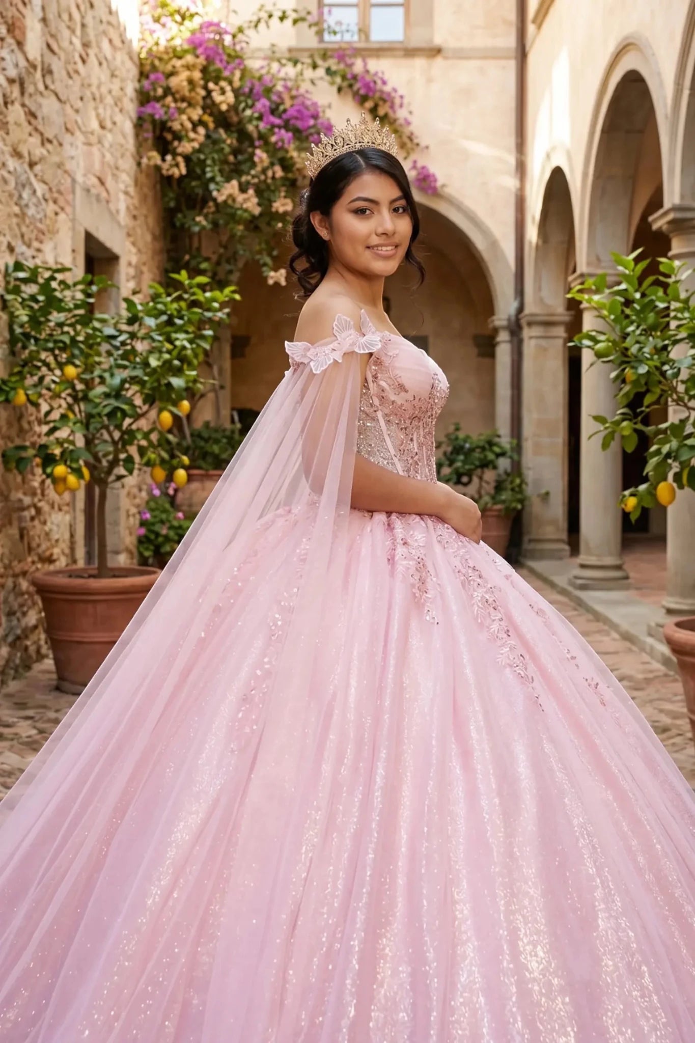 Side close-up of a woman wearing rose gold quinceanera ball gown with floral brooch embellishments and sheer cape detail