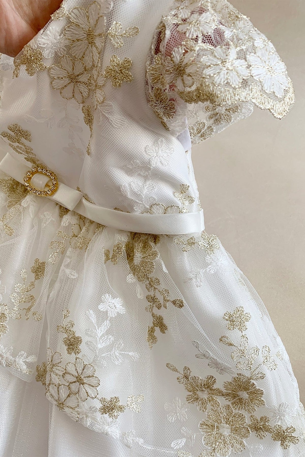 Detailed view highlights Baby Off-White lace flower girl dress with gold embroidery. Also suitable as a communion dress. Also.