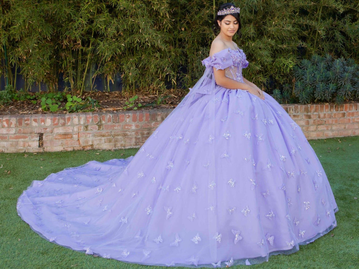 Side profile shows lilac quinceanera ball gown with butterfly appliques, puffed sleeves, and layered skirt.