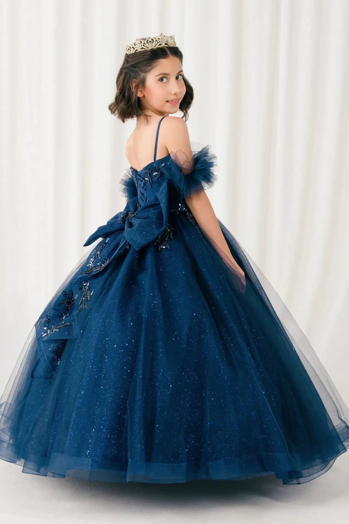 Back view of burgundy mini quinceañera mini quince dress with beaded bodice, floral appliqué, draped details, sparkling tulle skirt, and matching tulle arm cuffs.